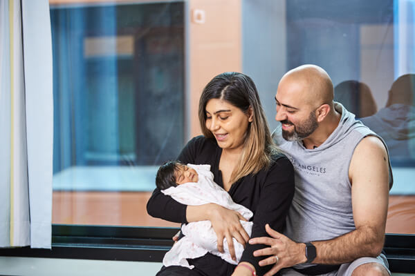 Preparing to go home New parents smile down at their newborn baby