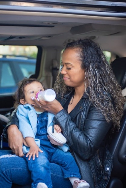 Caregiver feeding a baby with a bottle