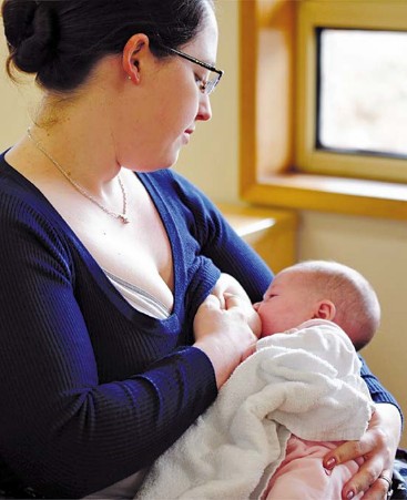 Blue sweater woman breastfeeding baby