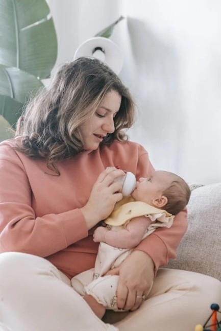 Caregiver feeding a baby with a bottle