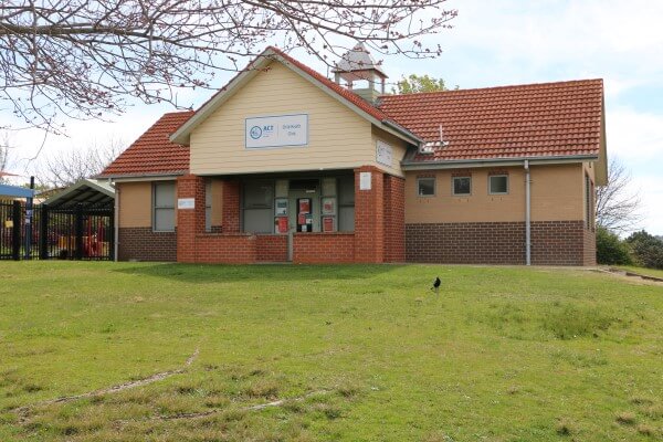 The exterior of the Florey Child Health Clinic building set on a grassy hill