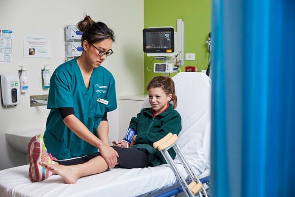 A doctor checks over a young girls leg for injuries
