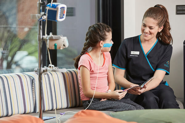 A young girl and a nurse read together A young girl and a nurse read together