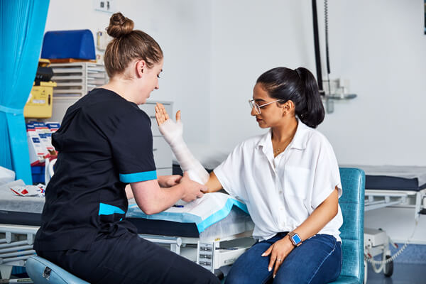 A nurse applies a bandage to a woman's arm at Canberra Hospital.