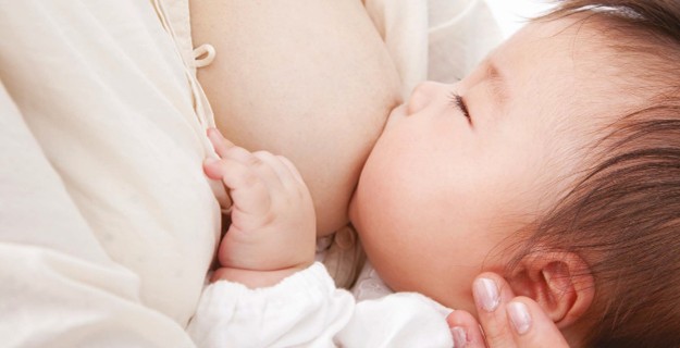 Baby breastfeeding with left hand out
