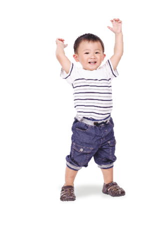 An 18 month old toddler is standing up waving his hands in the air.